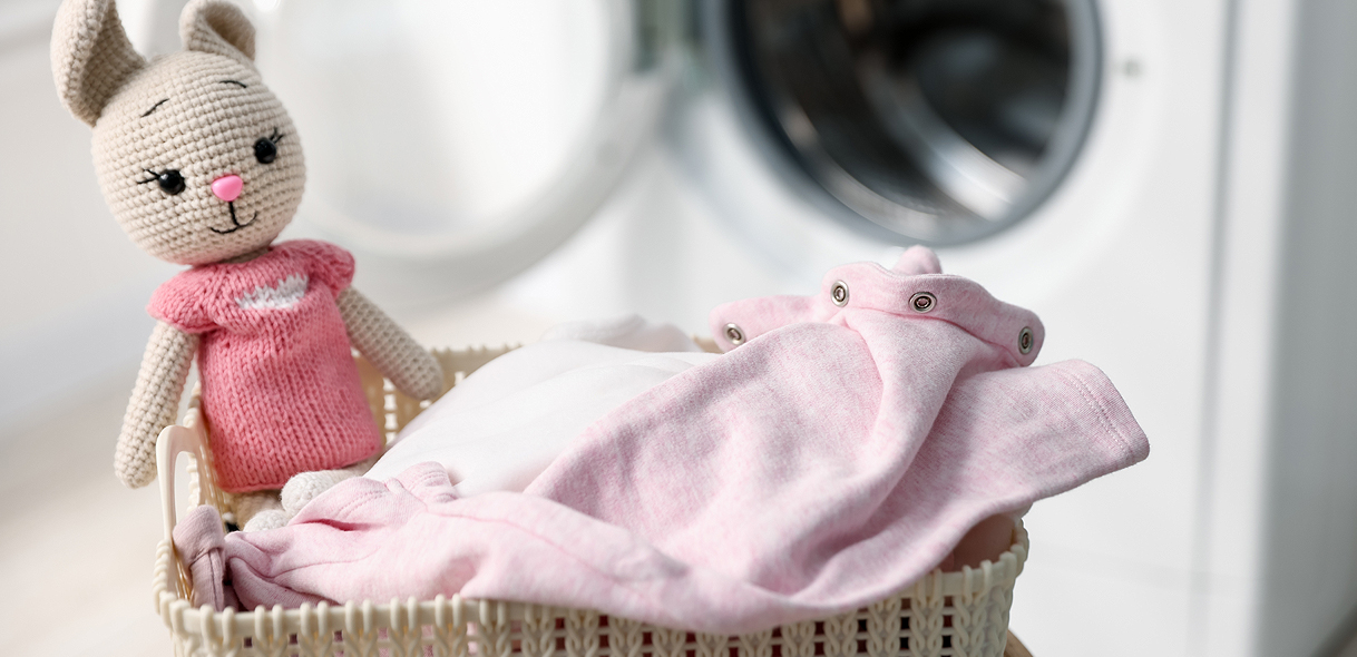 Wasmand met babykleding en knuffel voor wasmachine
