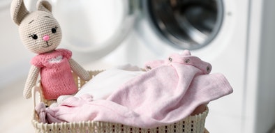 Wasmand met babykleding en knuffel voor wasmachine