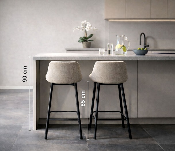 Twee beige barkrukken met zwart frame naast een grijs keukeneiland met maataanduiding van 90 cm tafelhoogte en 65 cm zithoogte