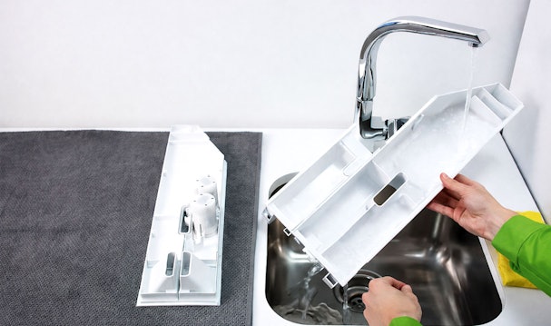 Wasmiddellade reinigen onder stromend water voor Siemens iDos onderhoud