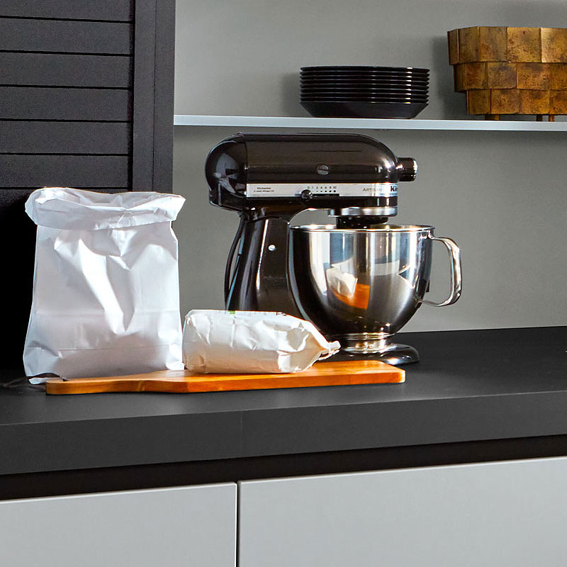 IJsblauwe fronten met donker werkblad en keukenmixer.