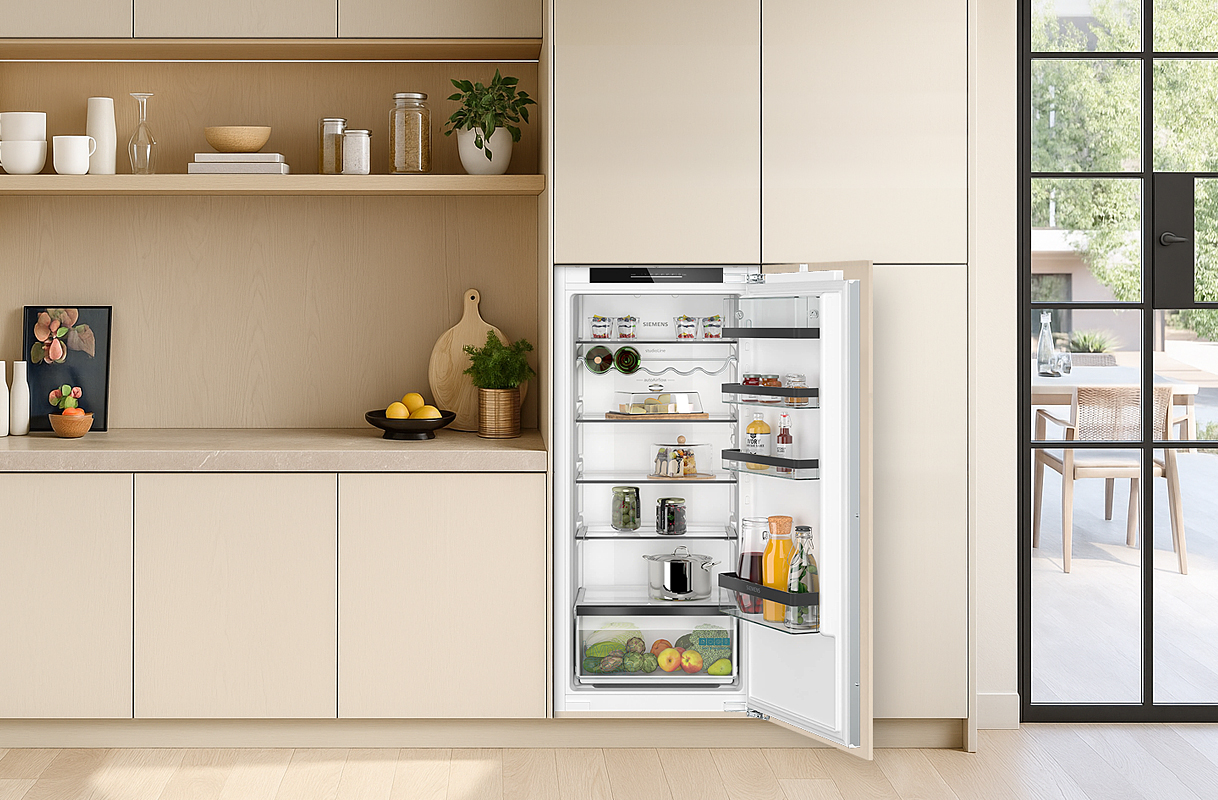Inbouw koelkast 102–122 cm geïntegreerd in lichte keuken, met open deur en overzichtelijke indeling.