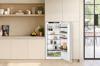 Inbouw koelkast 102–122 cm geïntegreerd in lichte keuken, met open deur en overzichtelijke indeling.