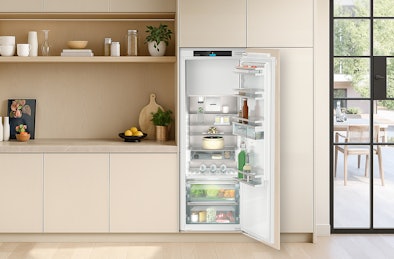 Inbouw koelkast 140–158 cm in lichte keuken, met open deur en ruime indeling met vershoudzones.