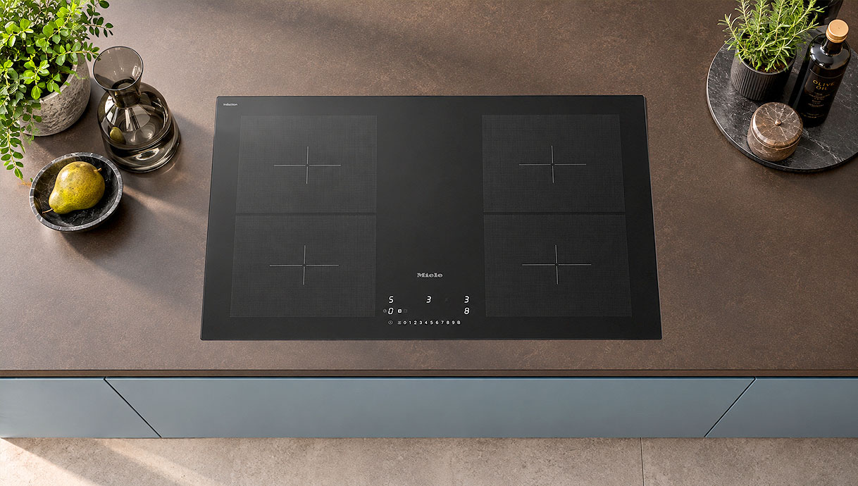 Inductie kookplaat met vier kookzones ingebouwd in het aanrechtblad van een moderne keuken