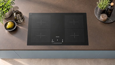 Inductie kookplaat met vier kookzones ingebouwd in het aanrechtblad van een moderne keuken