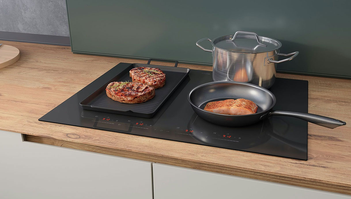70 cm inductiekookplaat met twee pannen en een braadslede op gekoppelde kookzones