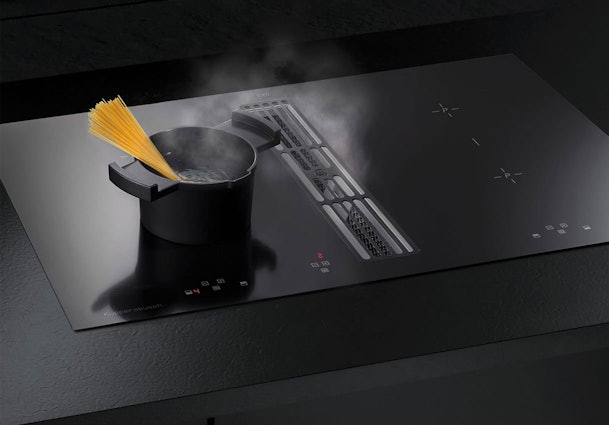 Küppersbusch inductiekookplaat met geïntegreerde afzuiging en pan met kokende pasta.