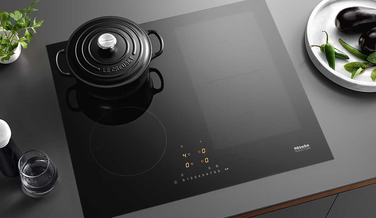 Miele inductiekookplaat 60 cm met zwarte braadpan en verlichte bedieningselementen
