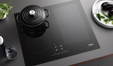 Miele inductiekookplaat 60 cm met zwarte braadpan en verlichte bedieningselementen