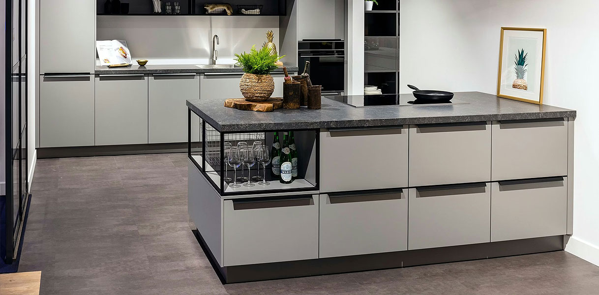 Industrieel schiereiland met betonlook werkblad, donkere fronten en open metalen rek in moderne keuken