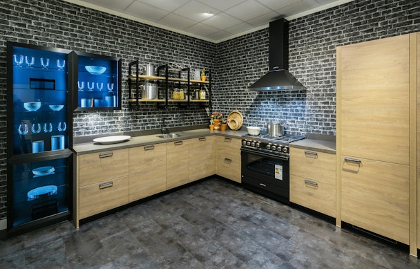 Een industriële keuken met materialen van beton, baksteen, hout en metaal.