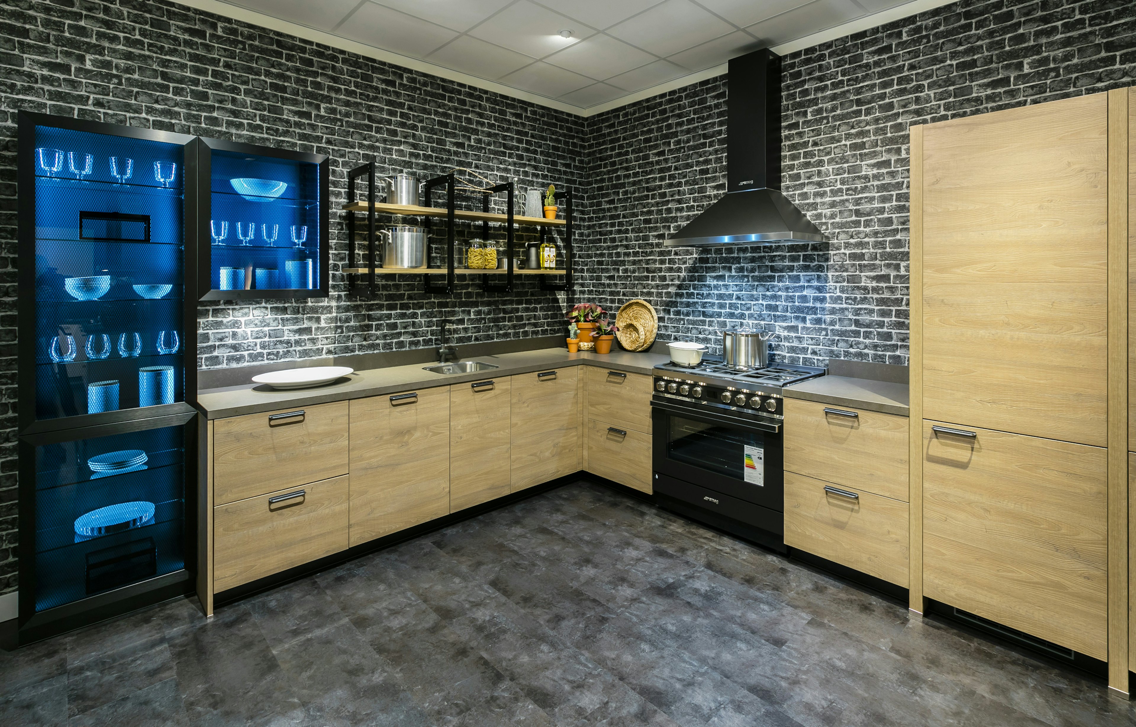 Een industriële keuken met materialen van beton, baksteen, hout en metaal.