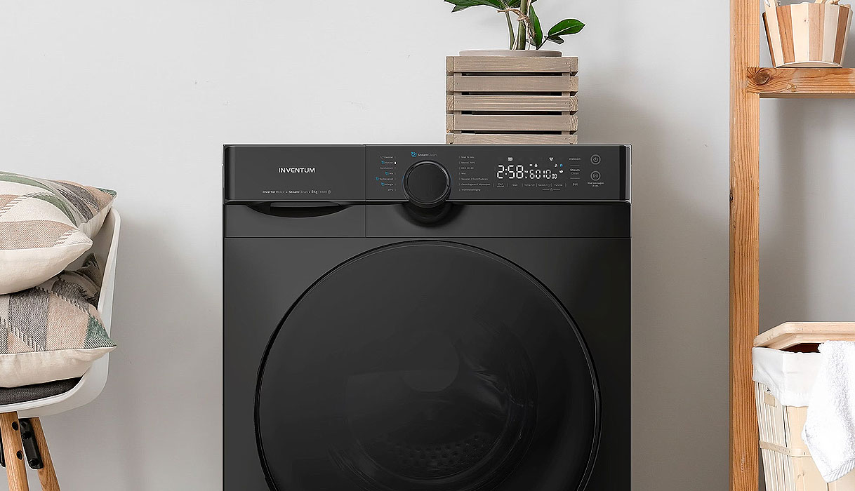 Zwarte Inventum wasmachine met digitaal display in stijlvolle wasruimte met groene plantendecoratie