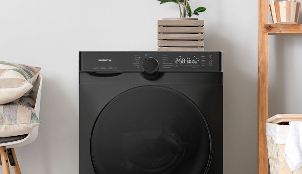 Zwarte Inventum wasmachine met digitaal display in stijlvolle wasruimte met groene plantendecoratie