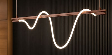 Strakke hanglamp met golvend LED lichtsnoer in koperkleurig frame tegen ribbenwand
