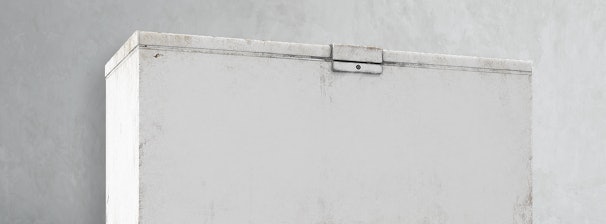 Bovenkant van een oude, versleten vrieskist die de leeftijd van het apparaat toont.