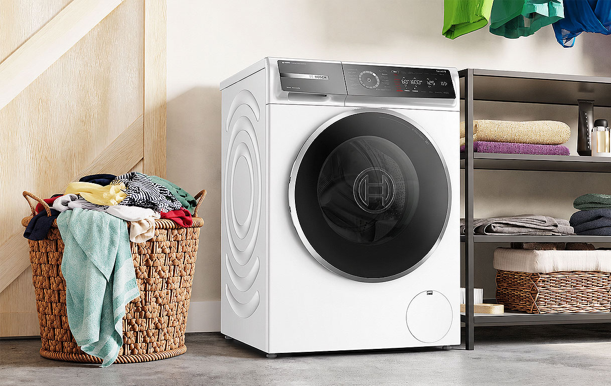 Bosch 10 kg wasmachine naast een volle wasmand als juiste keuze voor veel wasgoed