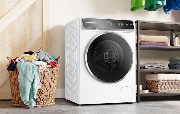 Bosch 10 kg wasmachine naast een volle wasmand als juiste keuze voor veel wasgoed