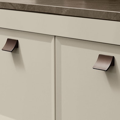 Bronzen kastgrepen op zandkleurig front.