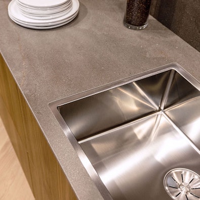 Spoelunit met een keramisch keukenblad en achterwand