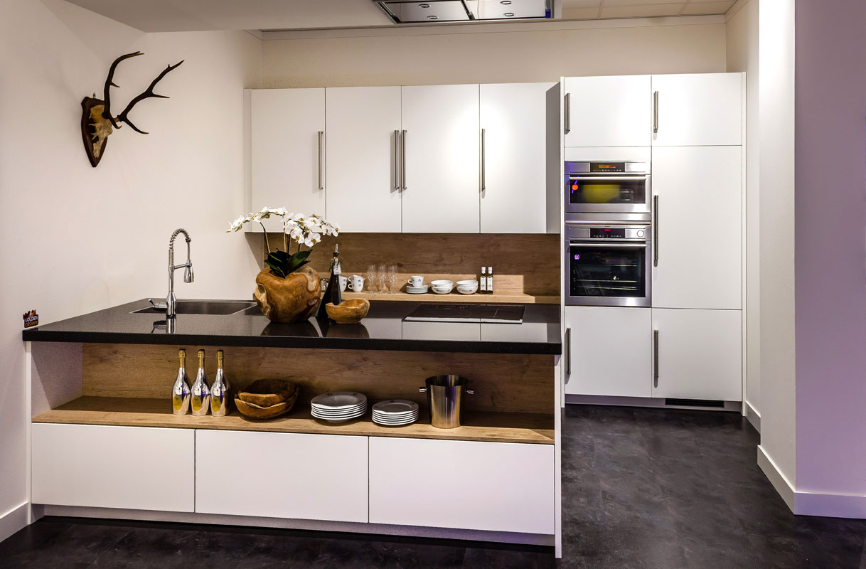 Witte opstelling met houtaccent en zwart werkblad