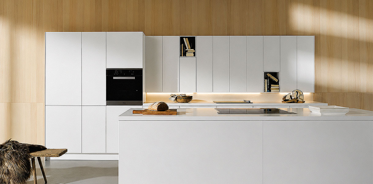 Moderne keuken met groot wit kookeiland en lichte houten wandkasten