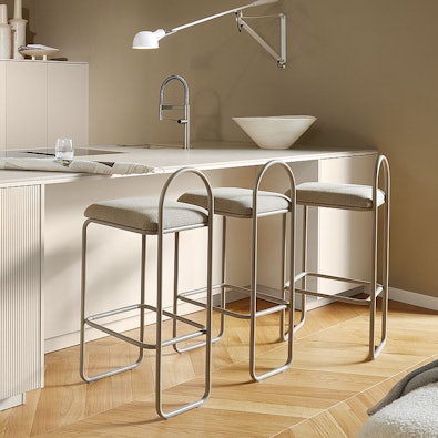 Lichte keukenbar met afgeronde hoeken en moderne barkrukken