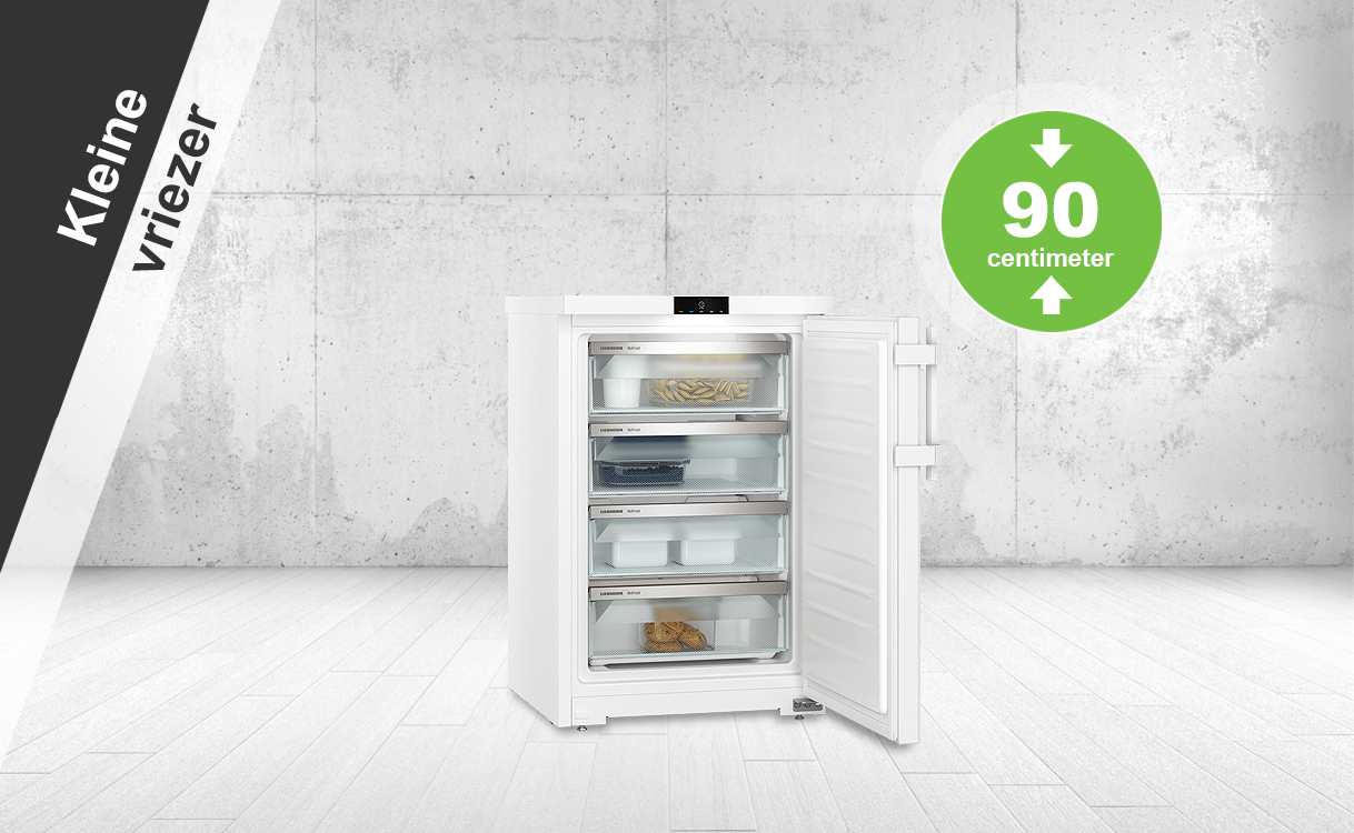 Kleine vriezer van circa 90 cm hoog met open deur en meerdere lades.