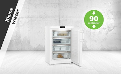 Kleine vriezer van circa 90 cm hoog met open deur en meerdere lades.