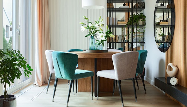 Compact modern appartement met ronde eettafel en groene stoelen toont beperkte ruimte en opbergbehoefte