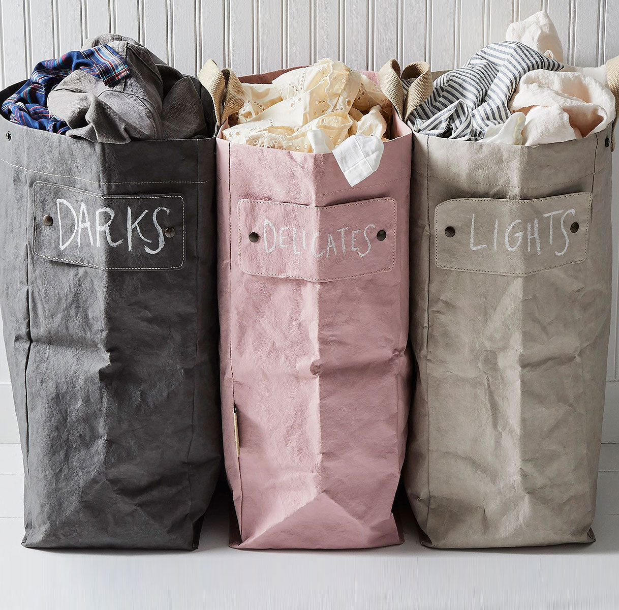 Drie waszakken met labels: Darks voor donkere was, Delicates voor fijne was en Lights voor lichte was