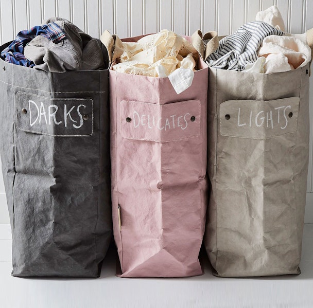 Drie waszakken met labels: Darks voor donkere was, Delicates voor fijne was en Lights voor lichte was