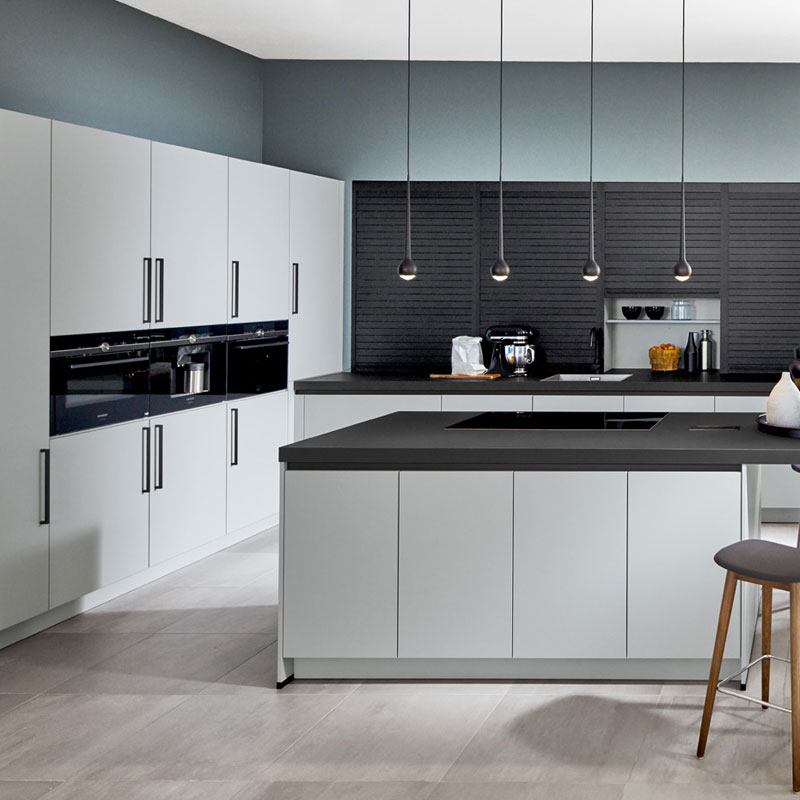 Moderne keuken met ijsblauwe kasten, grijs werkblad en koele grijsblauwe wandkleur die rust en een strakke uitstraling geeft.