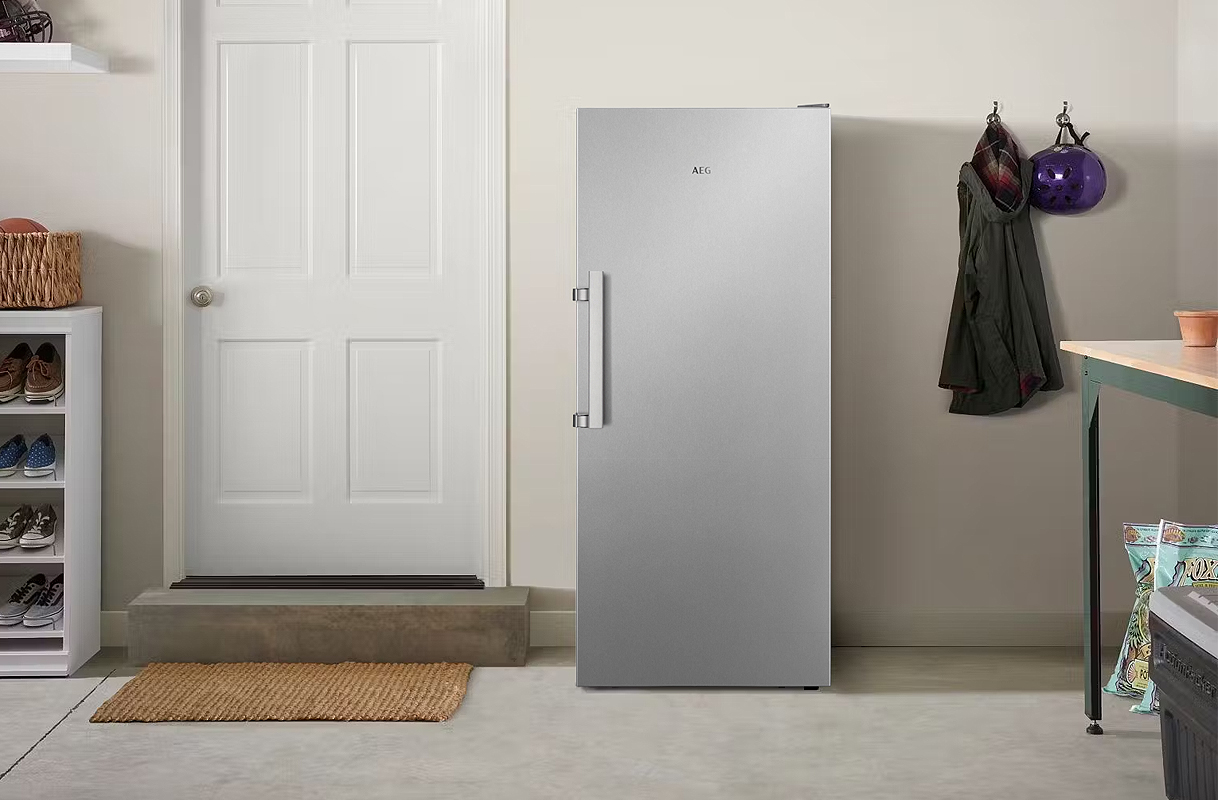 Vrijstaande AEG koelkast in een schuur naast een binnendeur, voorbeeld van koelkast voor in de schuur.