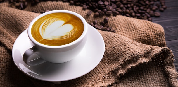 Koffie met koffiebonen op de achtergrond.