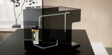Achterkant van een koffiemachine met bonen met waterfilter en ontkalkingssysteem zichtbaar