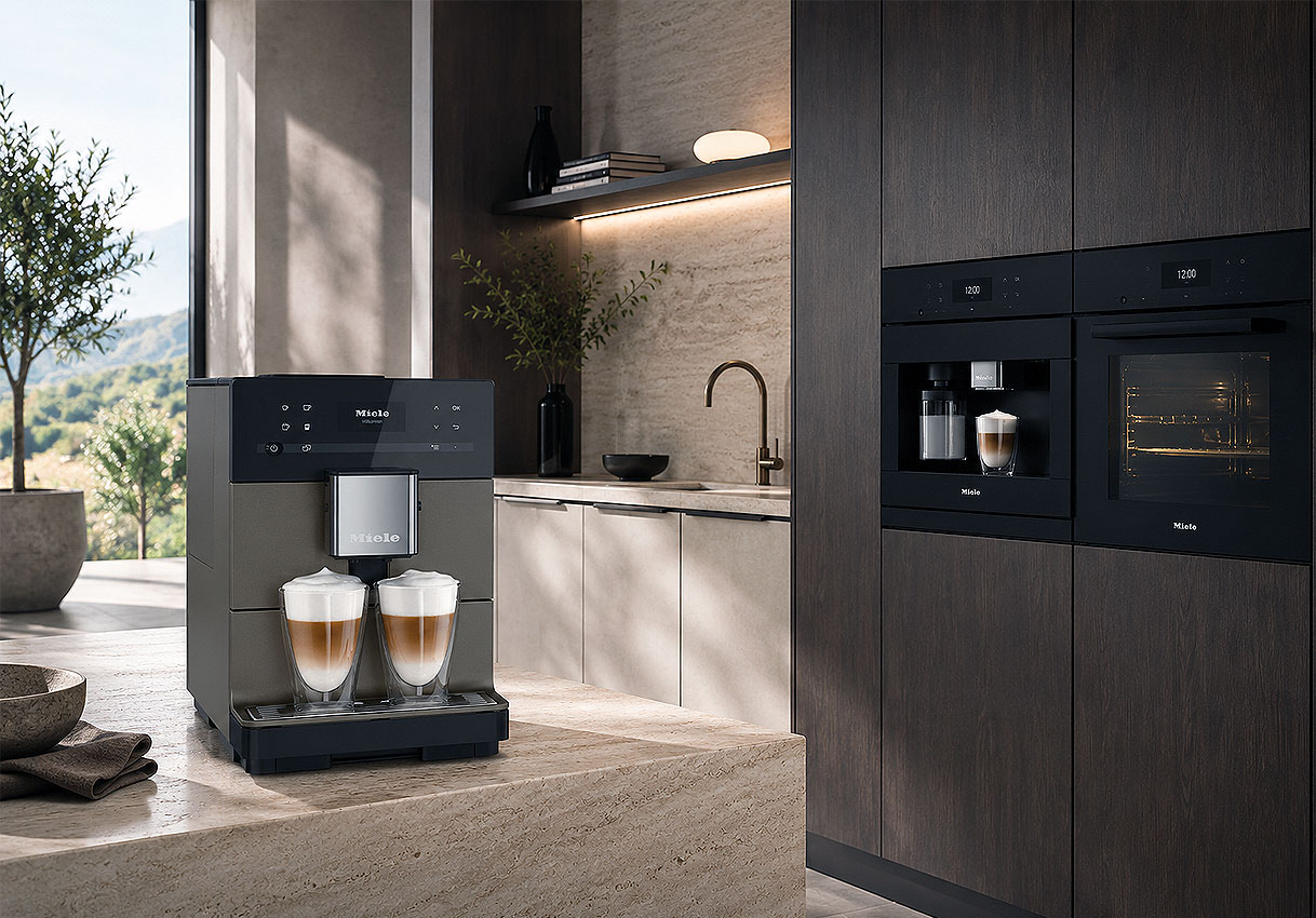 Vrijstaand Miele cappuccino apparaat op het aanrecht naast een ingebouwd model met oven in de keukenkast