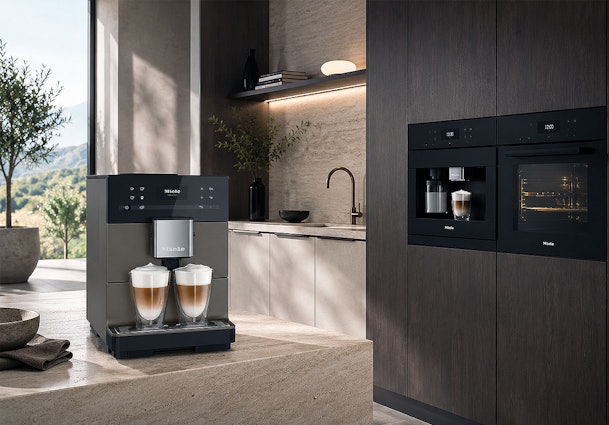 Vrijstaand Miele cappuccino apparaat op het aanrecht naast een ingebouwd model met oven in de keukenkast
