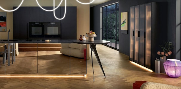 Asymmetrisch design kookeiland met gebogen, vrijstaand barblad en moderne verlichting