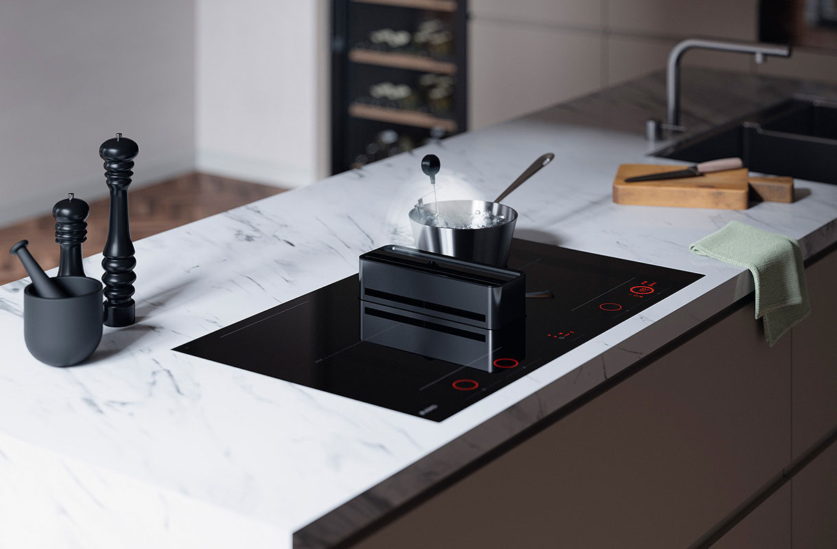 Kookplaat met ingebouwde afzuiging op marmeren kookeiland in moderne keuken