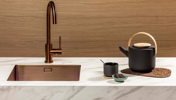 Koperen keukenkraan met een spoelbak in koper.