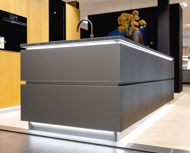 Modern kookeiland met greeploze kasten en strakke fronten als voorbeeld van keukenonderbouw