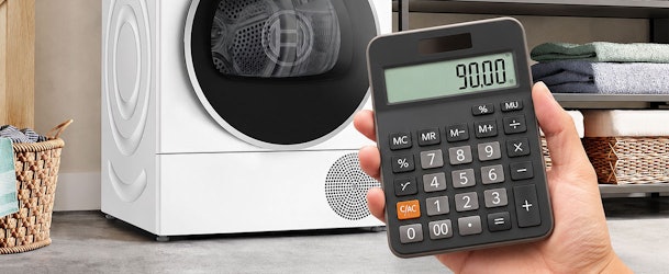 Hand met rekenmachine voor energiezuinige warmtepompdroger met jaarlijkse stroomkosten van ongeveer 90 euro