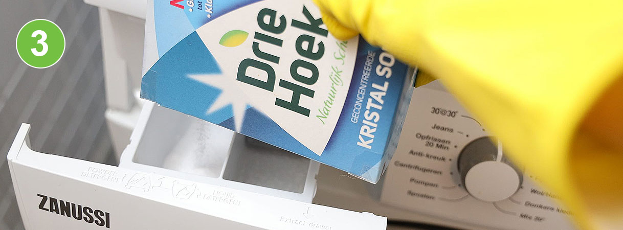 Kristalsoda toevoegen aan wasmachine: pak Driehoek kristalsoda wordt in het wasmiddelbakje van een Zanussi wasmachine geschud