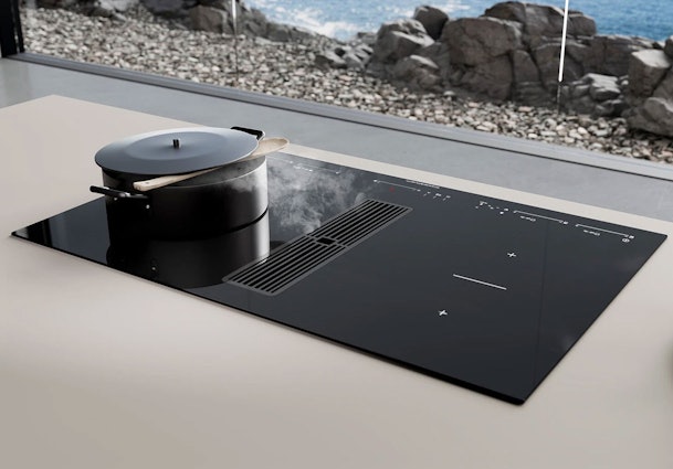 Küppersbusch inductiekookplaat met geïntegreerde afzuiging die kookdamp direct naast de pan afzuigt.