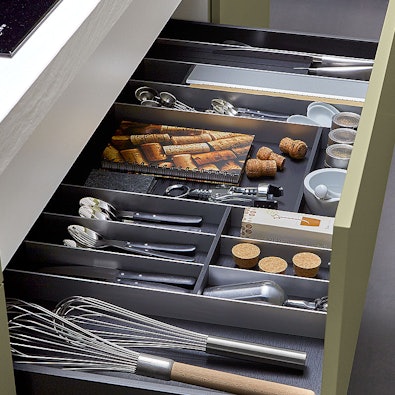 Georganiseerde lade met vakverdelers voor bestek en keukentools.