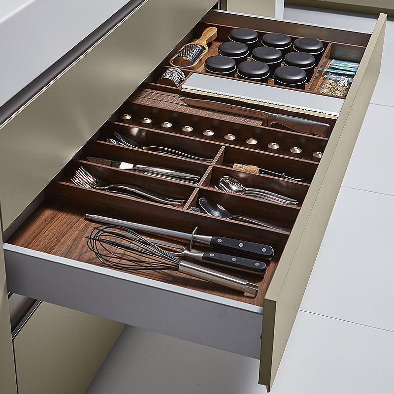 Lade met notenhouten indeling voor bestek en kruiden.