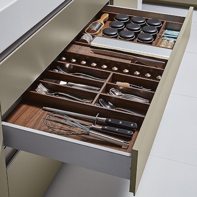 Lade met notenhouten indeling voor bestek en kruiden.