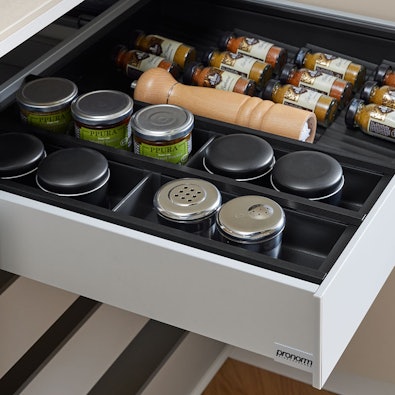 Georganiseerde lade met kruidenpotjes en accessoires